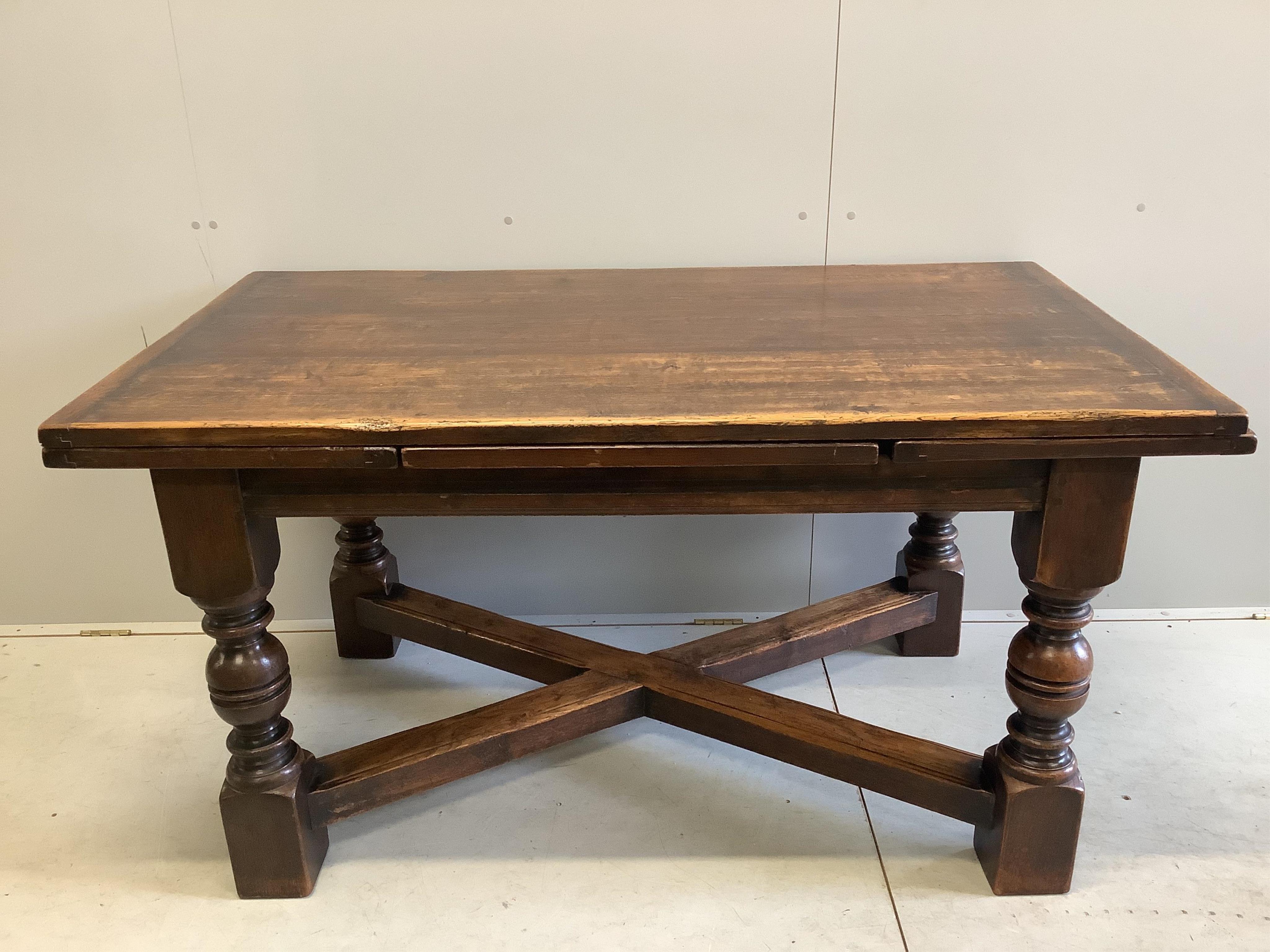 An 18th century style rectangular oak draw leaf refectory dining table, width 244cm extended, depth 85cm, height 79cm together with seven caned oak dining chairs, two with arms. Condition - fair to good